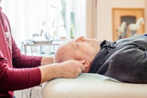 Male client receiving Cranial Sacral Massage Therapy at Sanctuary of Integration Wellness Center in a calm, therapeutic setting.